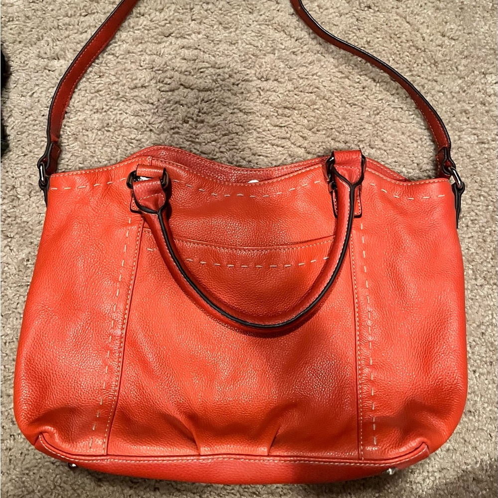 Women’s orange purse with strap and handles. Multiple inside pockets.